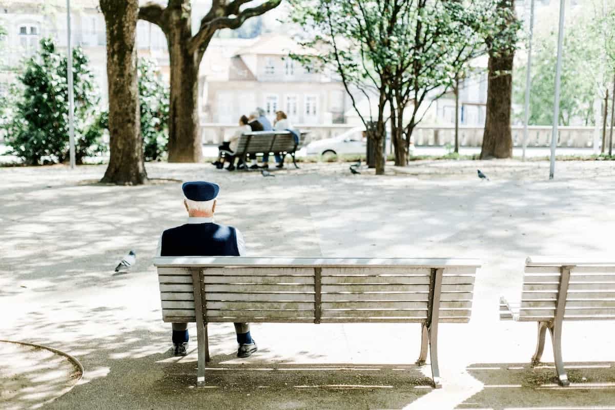 Öregember ül a padon a parkban